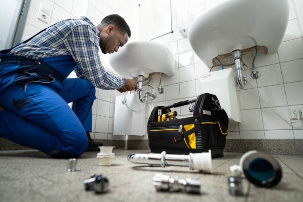 plumber fixing pipe in bathroom. plumbing maintenance in bathroom
